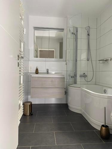 a white bathroom with a tub and a sink at Apartment Lahnblick in Marburg an der Lahn