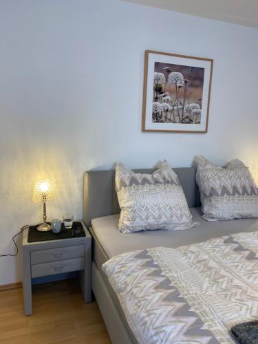 ein Schlafzimmer mit einem Bett und einem Beistelltisch mit einer Lampe in der Unterkunft Apartment Lahnblick in Marburg an der Lahn