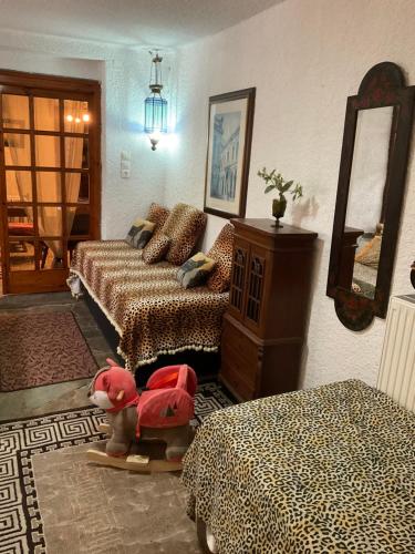 a living room with two beds and a mirror at House with Big Garden in Korinthos