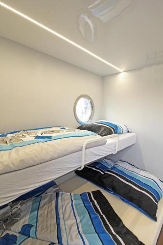 a bedroom with two bunk beds and a window at Festliegende Wohnboote Marina Niederhavel in Brandenburg an der Havel