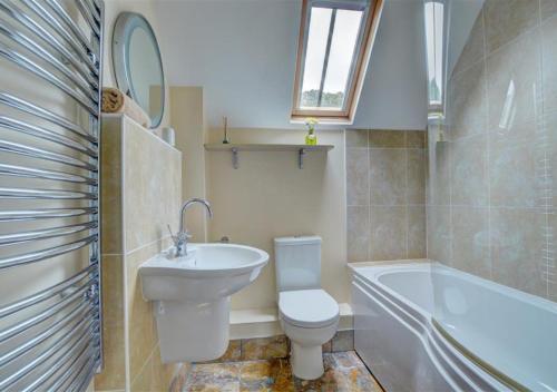 a bathroom with a toilet and a sink and a bath tub at Chapel Loft in Lynmouth