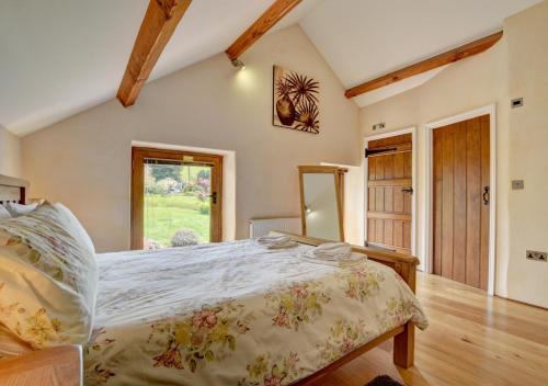 Un dormitorio con una cama grande y una ventana en Cider Pound, en Bampton