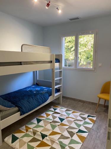 - une chambre avec des lits superposés et un tapis géométrique dans l'établissement Maison Monsegur, à Monségur