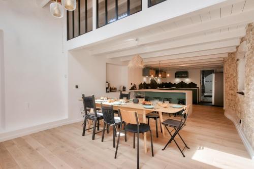 une salle à manger et une cuisine avec une table et des chaises dans l'établissement Belle maison avec jardin ombragé pour 11, au Bois-Plage-en-Ré