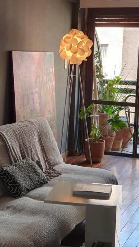 a living room with a couch and a table with a lamp at Departamento en Nueva Cordoba in Cordoba