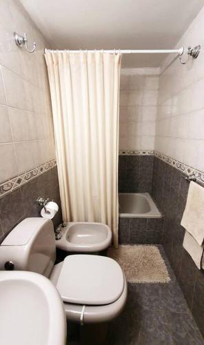 y baño con 2 aseos, lavamanos y ducha. en Departamento en Nueva Cordoba en Córdoba