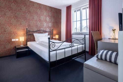 a bedroom with a bed and a red wall at Villa Neugarten in Hagnau