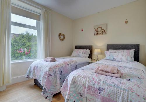1 dormitorio con 2 camas y ventana en Clifton House 4 Lynton, en Lynmouth