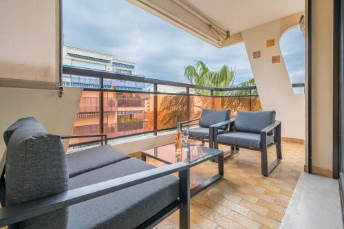 einen Balkon mit 2 Sofas und einem Tisch in der Unterkunft LE LONG BEACH Appartement pour 4 By Sunset Riviera Holidays in Juan-les-Pins