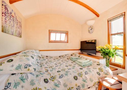 a bedroom with a bed and a flat screen tv at The Cloud in Bampton