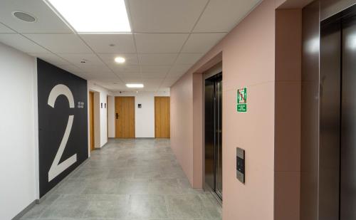 a hallway of an office building with a door and a sign at Milo Aparthotel in Wrocław