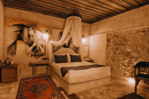 a bedroom with a bed and a painting on the wall at AKRİTİS STONE HOUSE in Urgup