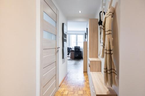 Zimmer mit einer Tür und einem Flur mit Holzböden in der Unterkunft NiceOne Apartment Number 1 - W samym Centrum! in Breslau