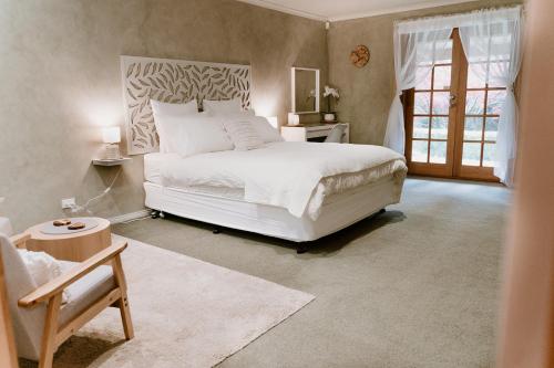 Un dormitorio con una gran cama blanca y una ventana en The Cherry Blossom Suite, en The Patch