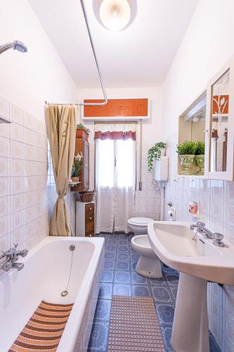 a bathroom with two sinks and a tub and two toilets at La Romana Antica in Madonna di Fornelli