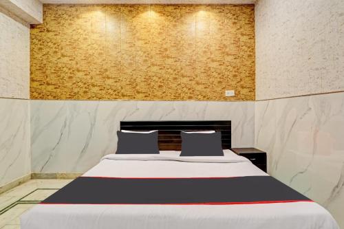 a bedroom with a large bed with two pillows at OYO Flagship Hotel Tri Palace in Kānpur