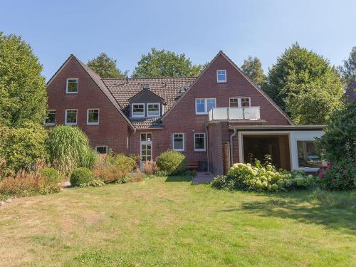 a large red brick house with a yard at Ferienwohnung Fresenhuus 3, FeWo Vermittlung Nordsee in Dangast