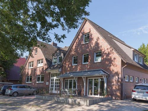 a large brick building with cars parked in front of it at Ferienwohnung Fresenhuus 3, FeWo Vermittlung Nordsee in Dangast