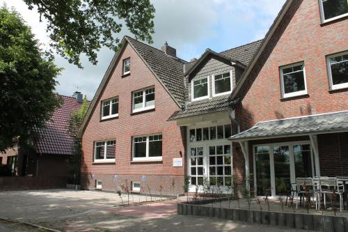 un bâtiment en briques avec des tables et des chaises devant lui dans l'établissement Ferienwohnung Reethuus 6, FeWo Vermittlung Nordsee, à Dangast