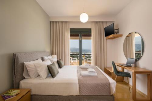 um quarto de hotel com uma cama, uma secretária e uma janela em Villa City View - Heated Pool - Majestic views - 5 min drive from center em Chania Town