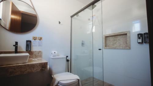 La salle de bains est pourvue d'une douche, d'un lavabo et d'un miroir. dans l'établissement Pousada Pérola Do Morro, à Morro de São Paulo