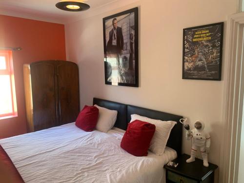 a bedroom with a bed with red and white pillows at Southsea Royale James Bond 3 bed Cool Penthouse, seafront parking in Portsmouth