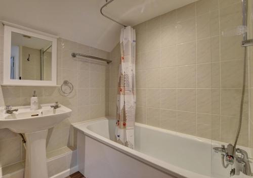 a bathroom with a sink and a bath tub and a sink at The Cottage in Trentishoe