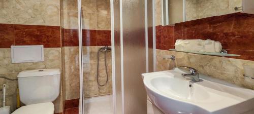 ein Bad mit einem WC, einem Waschbecken und einer Dusche in der Unterkunft Crown and Imperial Apartments in Sweti Wlas