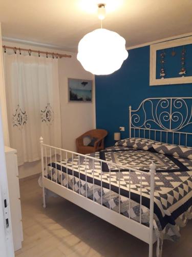 a bedroom with a bed with a blue wall at Appartamento Cavo in Cavo