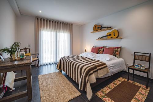 a bedroom with a bed with a guitar on the wall at Advania Country House in Lourinhã