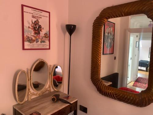 a room with two mirrors and a wooden table at Southsea Royale James Bond 3 bed Cool Penthouse, seafront parking in Portsmouth
