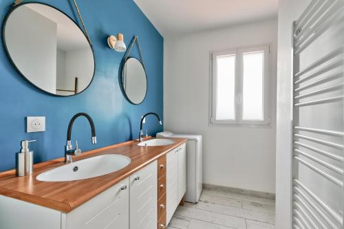 ein Badezimmer mit zwei Waschbecken und zwei Spiegeln in der Unterkunft La Guérinière - 650m de la plage - Jardin in La Guérinière