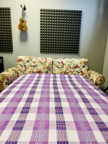 a couch with a blanket on it with a guitar at Office Room 