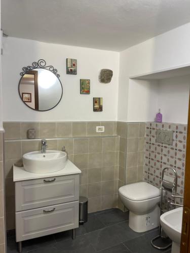 a bathroom with a sink and a toilet and a mirror at New Ca de na volta - tra Liguria e Toscana in Albiano