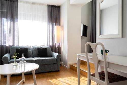 a living room with a couch and a table at Elite Stadshotellet Växjö in Växjö