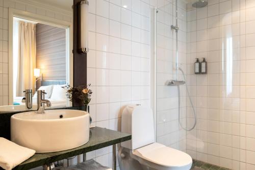 a bathroom with a sink and a toilet and a shower at Elite Stadshotellet Växjö in Växjö
