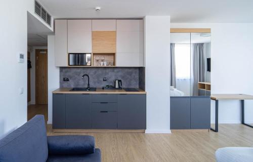 Milo Aparthotel في فروتسواف: مطبخ مع خزائن زرقاء وأريكة زرقاء