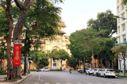 a street with cars parked on the side of the road at High-class French villa 168m2 by SSens Homes in Hanoi