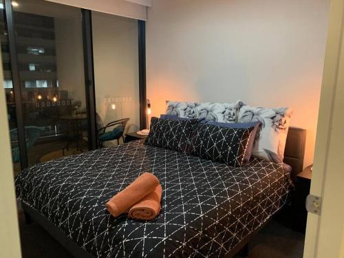 a bedroom with a bed with two towels on it at Plush @ Benjamin way Belconnen in Belconnen