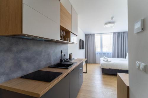 una cocina con fregadero y una cama en una habitación en Milo Aparthotel, en Wroclaw