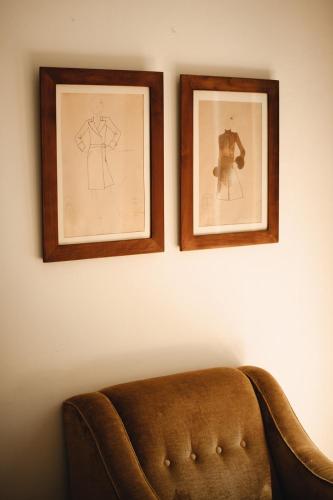 two framed pictures on a wall next to a couch at Le dimore de Il borgo del balsamico in Albinea