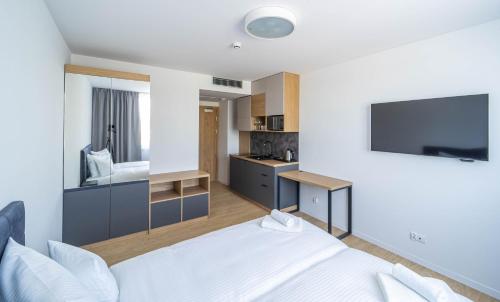 a hotel room with a bed and a television at Milo Aparthotel in Wrocław