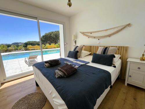 um quarto com uma cama e vista para uma piscina em Villa 6 Chambres, Piscine, vue Mer, à Proximité de la Plage , Cavalaire-sur-mer em Cavalaire-sur-Mer