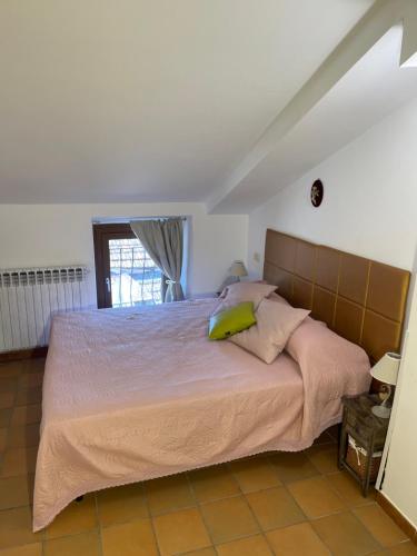 a bedroom with a bed with pink sheets and green pillows at New Ca de na volta - tra Liguria e Toscana in Albiano