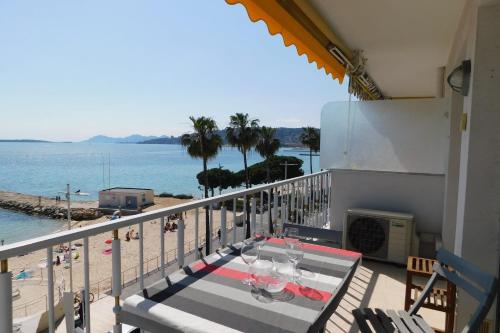 a balcony with a table and a view of the beach at Splendid T2 "San Remo" waterfront air-conditioned and with parking in Juan-les-Pins