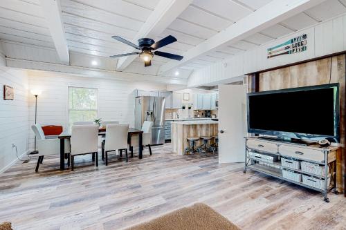 a living room with a dining table and a flat screen tv at Peck's Perch in Alder