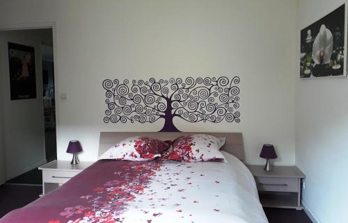 un lit avec tête de lit d'arbre et fleurs rouges dans l'établissement Havre de paix entre mer et montagne à Céret pour 4 à 5 pers, à Céret