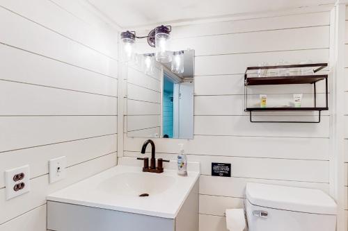 uma casa de banho branca com um lavatório e um espelho em Peck's Perch em Alder