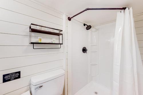 a white bathroom with a shower and a toilet at Peck's Perch in Alder