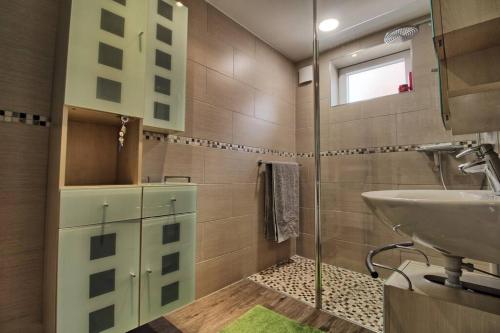 a bathroom with a sink and a glass shower at Aux grains de raisin - 6 personnes - cour privée in Scherwiller